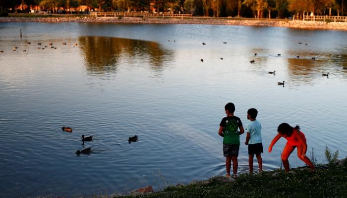 أطفال يطعمون البط بمتنزه سياحي إسباني- رويترز