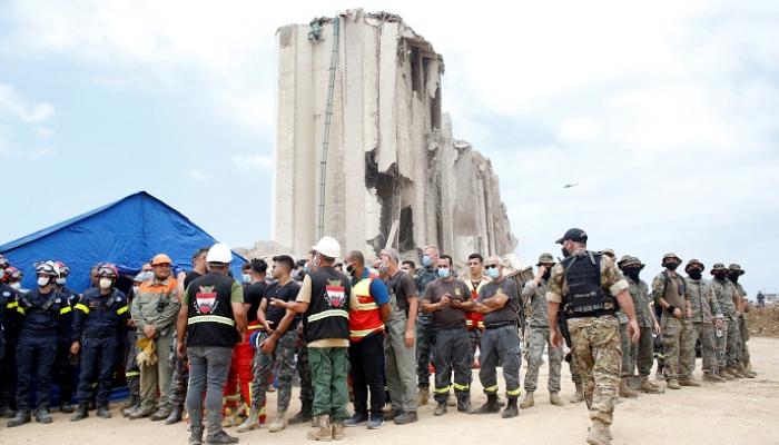 عمال الإنقاذ يقفون في موقع انفجار ميناء بيروت - رويترز