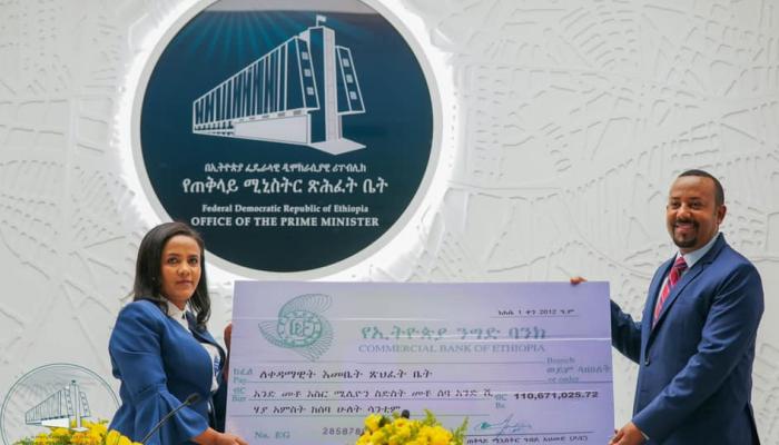 آبي أحمد خلال تسليمه التبرع للسيدة الأولى في إثيوبيا