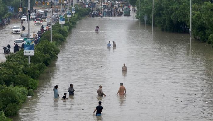 باكستانيون يستمتعون بالسباحة في مياه الأمطار