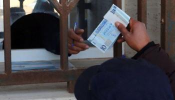 موظف بأحد مصارف ليبيا يحصي أوراقًا من فئة الـ10 دينارات. (أرشيفية)