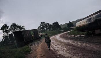 جندي من الكونغو يسير وسط حافلات مدمرة في اشتباكات