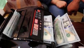 موظف بأحد مصارف ليبيا يحصي أوراقًا من فئة الـ100 دولار. (أرشيفية)ليبيا