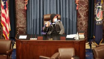 أحد المتظاهرين يحتل مقعد رئيس مجلس الشيوخ