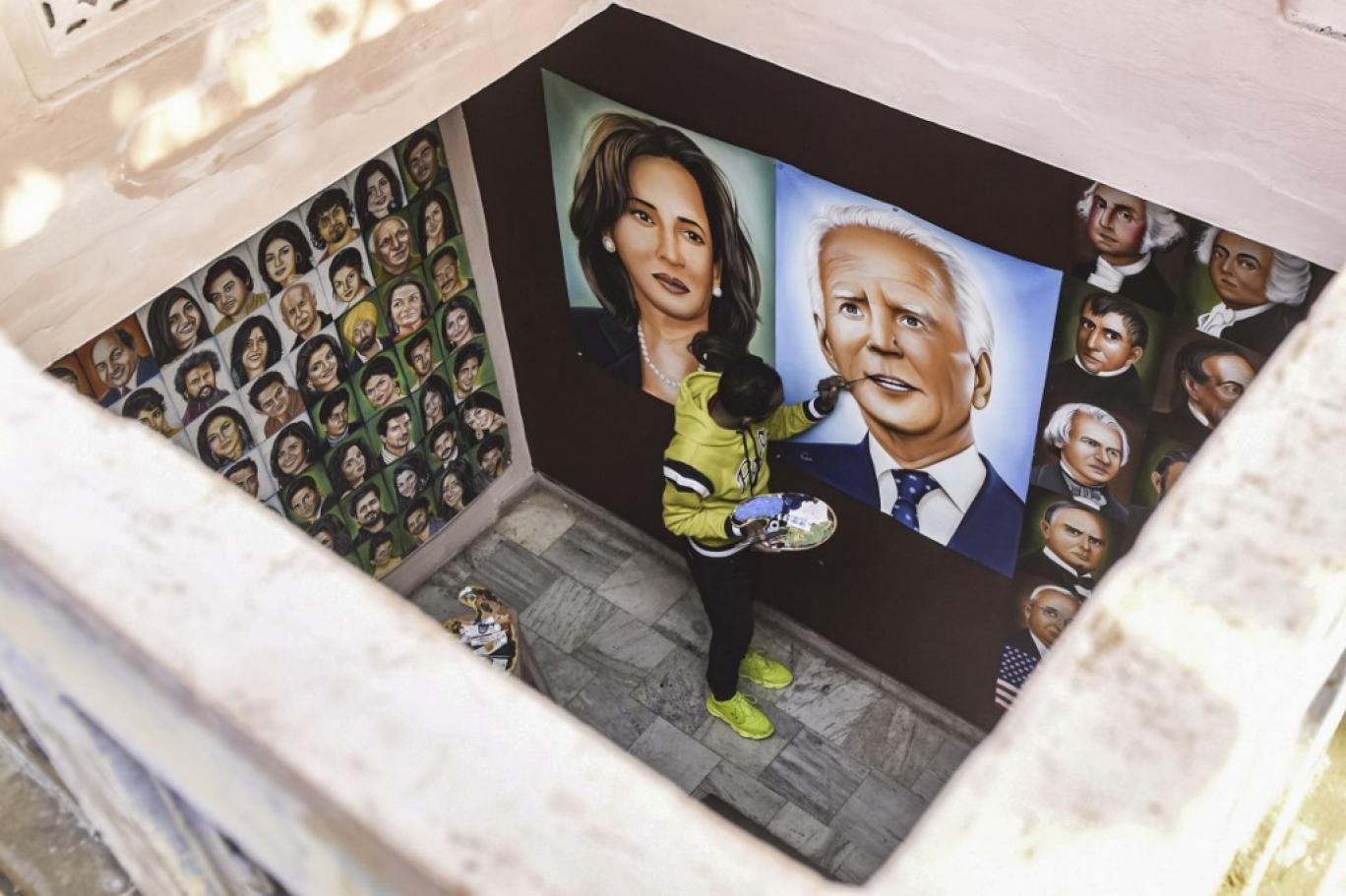 یک نقاش در حال کشیدن تصویری از جو بایدن و کامالا هریس-  AFP