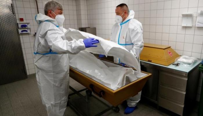  أطباء ألمان يضعون جثة أحد المتوفين بكورونا في تابوت