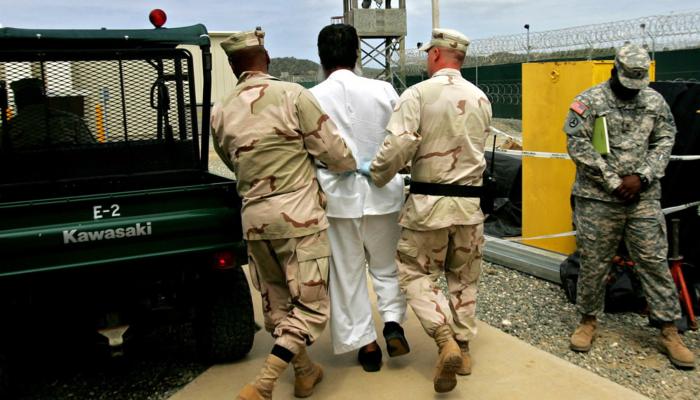 جنود أمريكيون رفقة أحد المعتقلين في جوانتانامو- أرشيف