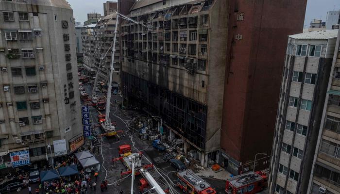 رجال الإطفاء يحاولون إخماد الحريق في المبنى