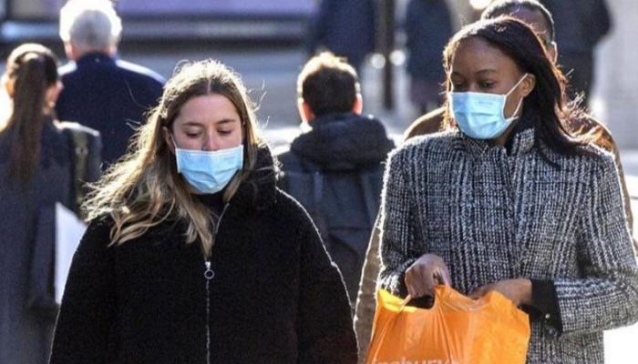 سيدتان تسيران في الشارع بالكمامة