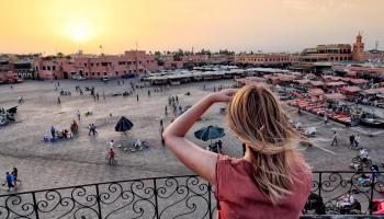 سائحة أجنبية تطل على ساحة جامع الفنا بمراكش - أرشيف