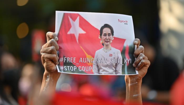 متظاهر يحمل صورة زعيمة ميانمار المعتقلة 