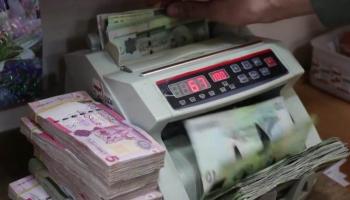 موظف بأحد مصارف ليبيا يحصي أوراقًا من فئة الـ10 دنانير (أرشيفية)