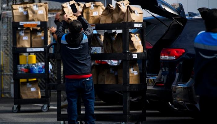 مركبة محملة بأكياس بقالة بمنشأة توزيع لأمازون في كاليفورنيا- أ ف ب