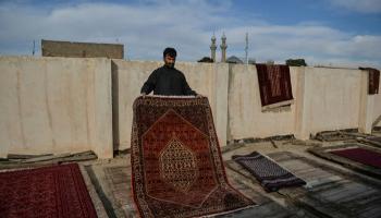 تاجر يعمل على تجفيف سجاداته بتعريضها لاشعة الشمس في مدينة هيرات الأفغانية
