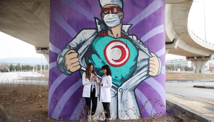 طلاب بكلية الطب في تركيا أمام رسم جرافيتي