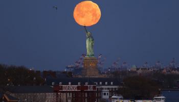 القمر العملاق فوق تمثال الحرية في نيويورك بالولايات المتحدة الأمريكية