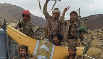 عناصر الجيش اليمني بجانب الطائرة الحوثية التي تم إسقاطها