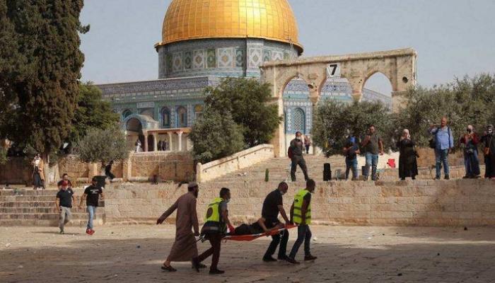 فلسطينيون يحملون مصابا جراء المواجهات مع القوات الإسرائيلية بالأقصى