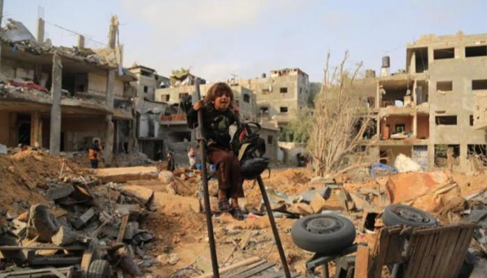 طفل يلهو قرب أحد المنازل المدمرة في غزة