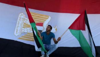  شاب يحمل العلم الفلسطيني وخلفه علم مصر - أرشيفية 