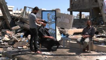 حلاق فلسطيني يصر على ممارسة مهنته فوق ركام محله في غزة