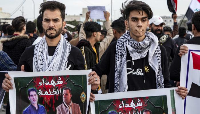 متظاهرون يرفعون صور صحفيين اغتيلوا مطلع العام الماضي