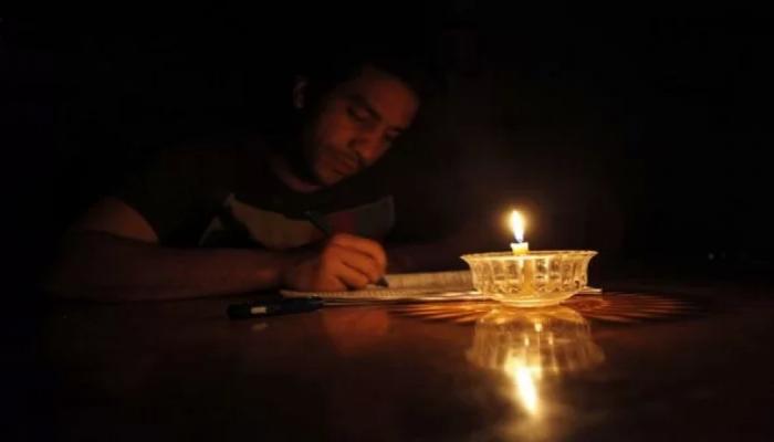 طالب لبناني يراجع دروسه على أضواء الشموع