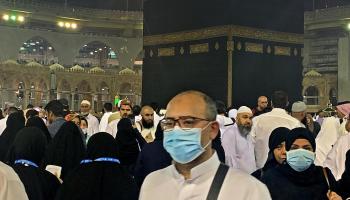 أحد زوار بيت الله الحرام يرتدي كمامة
