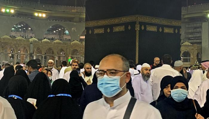 أحد زوار بيت الله الحرام يرتدي كمامة