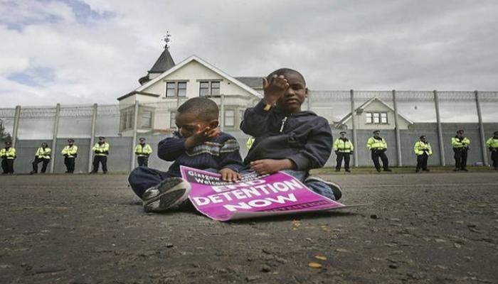 طفلان أفريقيان أمام أحد مواقع احتجاز اللاجئين ببريطانيا - أرشيفية