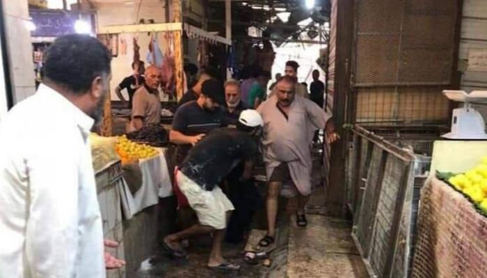 مواطنون يسعفون أحد جرحى انفجار مدينة الصدر