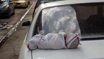 طفل رضيع أعلى ظهر سيارة عند أحد أزقة الموصل شمالي العراق