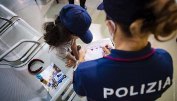 إحدى الشرطيات الإيطاليات ترسم مع طفلة أفغانية