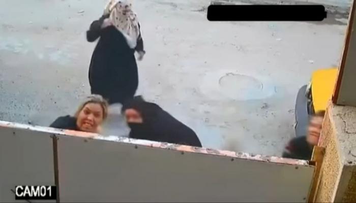 صورة ملتقطة من مقطع فيديو لنساء يهاجمن أحد المنازل بالحجارة