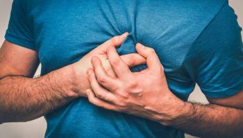 شاب يمسك بقلبه بعد إصابته بآلام - تعبيرية