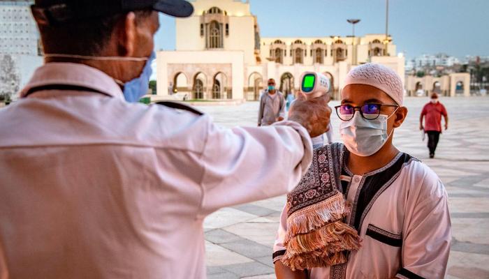 رجل أمن خاص يتحقق من درجة حرارة أحد المُصلين - أرشيف