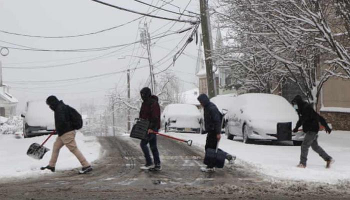 أمريكيون يحاولون إزاحة الثلوج عن الطريق في ولاية فرجينيا
