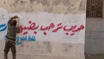 أحد أهالي حريب يزيل شعارات الحوثي 