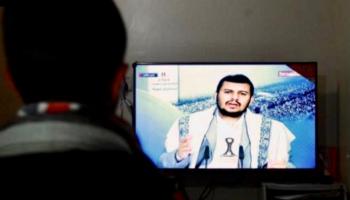 شخص يتابع زعيم مليشيات الحوثي في التلفاز