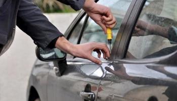 شخص يحاول فتح سيارة بطريقة غير مشروعة - تعبيرية