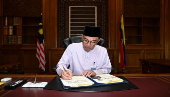 رئيس وزراء ماليزيا أنور إبراهيم يوقع وثيقة - رويترز
