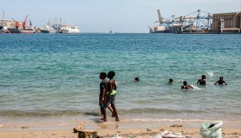 أطفال يسبحون في الماء بالقرب من السفن الراسية في بورتسودان