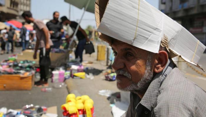 مواطن عراقي يحتمي من حرارة الصيف بغطاء كرتوني