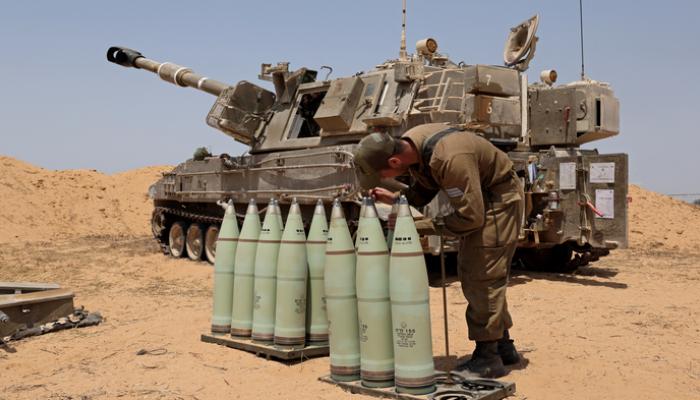 جندي إسرائيلي يستعد لإطلاق قذائف مدفعية باتجاه غزة