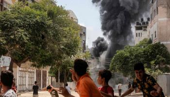 أطفال فلسطينيون يفرون بعيدا عن موقع غارة إسرائيلية في غزة