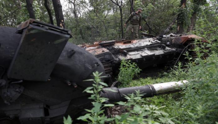 جندي أوكراني فوق دبابة روسية مدمرة