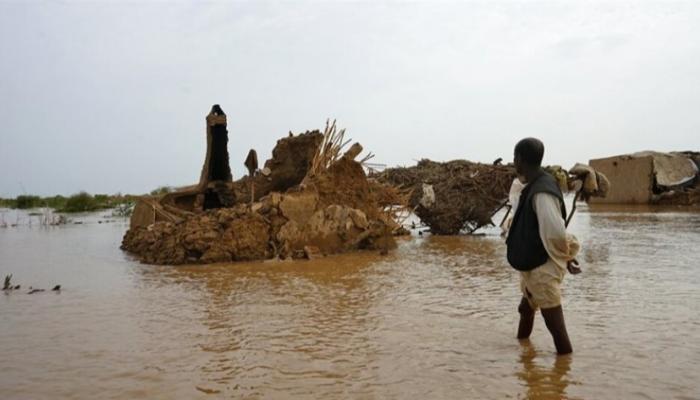 رجل يقف وسط مياه السيول في السودان