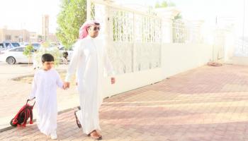 أب يصطحب نجله إلى المدرسة في أول أيام الدراسة