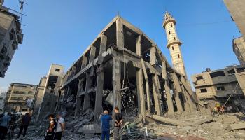 فلسطينيون يتجمعون حول أنقاض مسجد دمرته غارات إسرائيلية في قطاع غزة - رويترز