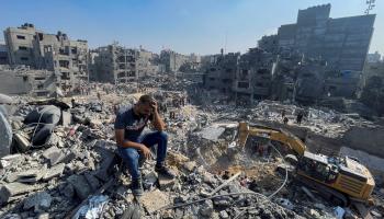 فلسطيني يجلس على أنقاض منزله المدمر في مخيم جباليا - رويترز